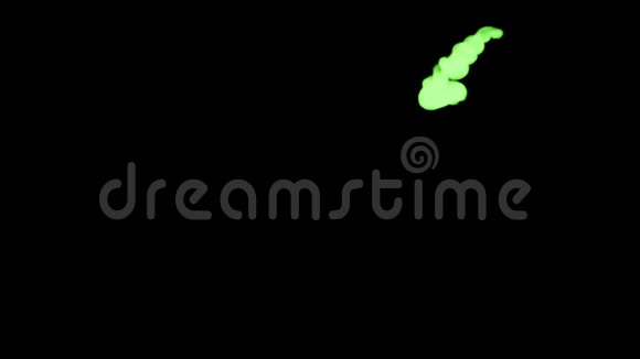 黑色背景上的荧光绿色墨水从上到下溶解在水中作为通道视频的预览图