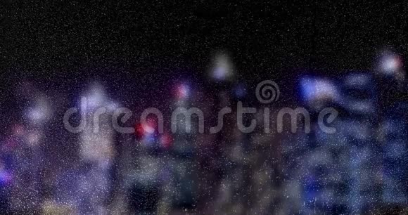 雨滴落在玻璃窗上多种颜色的灯光在夜晚摩天大楼的城市背景下水滴视频的预览图