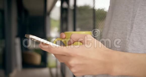 男人在家里用手机喝咖啡视频的预览图