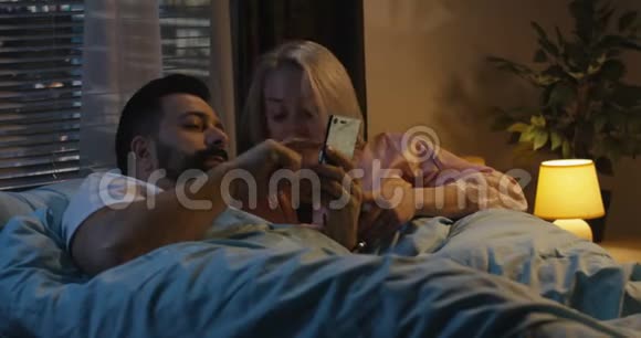 在床上用智能手机的情侣视频的预览图