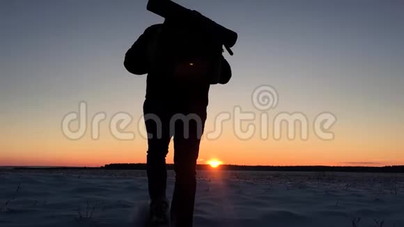 冬天背包客在雪山上散步希克在日落时走在雪地里背着背包在山上徒步旅行的人视频的预览图