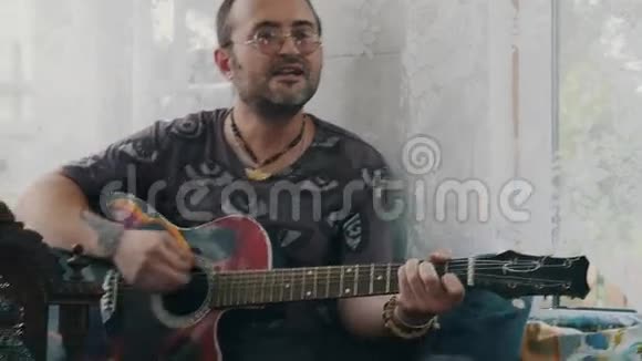 男人在乡间别墅的露台上弹吉他女孩喝酒同桌的朋友视频的预览图