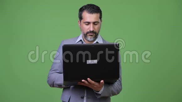 英俊的波斯胡子商人在用笔记本电脑思考视频的预览图