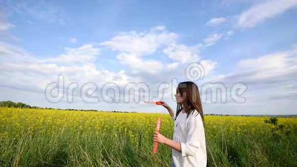 夏天快乐的小女孩在绿色草地上玩肥皂泡视频的预览图