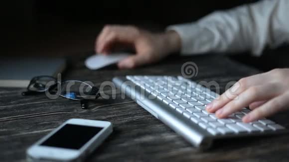 一个现代化的工作场所夜间工作一个人坐在电脑前在键盘上打字视频的预览图