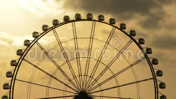 日落时分在游乐园里旋转的摩天轮的剪影视频的预览图