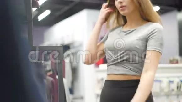 时髦的女孩在时尚的精品店里看衣服4K视频的预览图