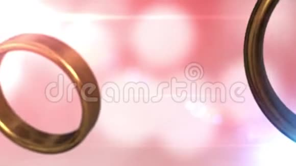 两个金色结婚戒指与美丽的粉红色背景融合在一起视频的预览图