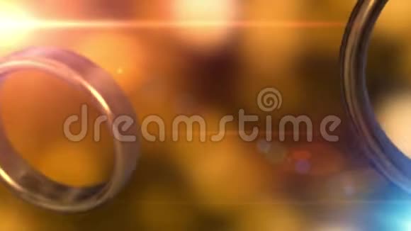 两个金色结婚戒指与美丽的金色背景融合在一起视频的预览图