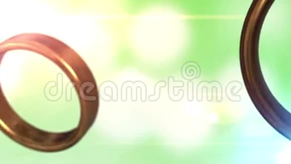 两个金色结婚戒指与美丽的绿色背景融合在一起视频的预览图