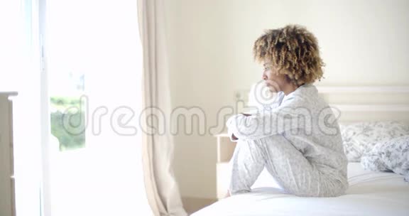 悲伤的女人坐在床上视频的预览图