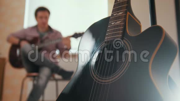 年轻迷人的音乐家用吉他和戏剧作曲还有其他的乐器视频的预览图