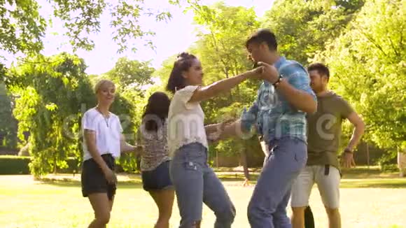 快乐的朋友在公园的夏季舞会上跳舞视频的预览图