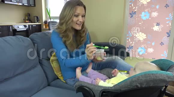 贪玩的女人在家里把土豆泥放进婴儿嘴里4K视频的预览图