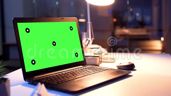 夜间办公室配有绿色屏幕的笔记本电脑视频的预览图