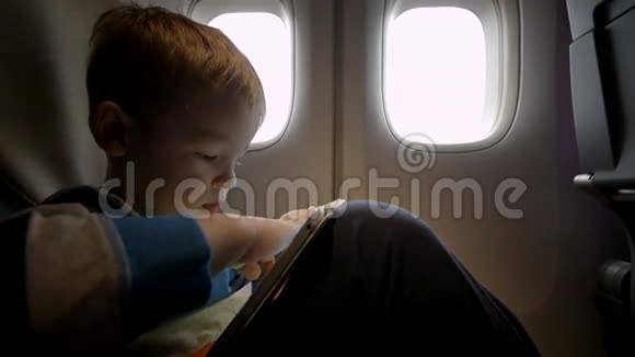 小男孩在飞机上玩触摸板视频的预览图
