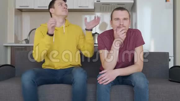 两个人正在看电视上的足球赛视频的预览图