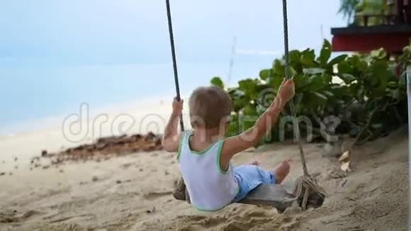 快乐的孩子在沙滩上荡秋千视频的预览图