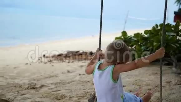 快乐的孩子在沙滩上荡秋千视频的预览图