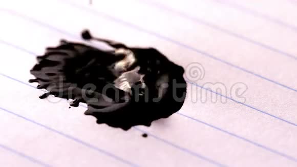 黑色墨水落在衬纸上视频的预览图