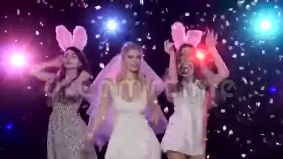 在单身派对上跳舞的女孩子对着频闪灯的五彩纸屑视频的预览图