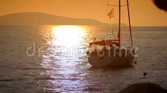 日落时分在海中的游艇在群山的背景下视频的预览图