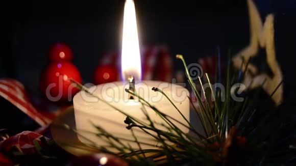 在雪地和木制背景下燃烧蜡烛和圣诞装饰优雅的拍摄与节日的心情视频的预览图