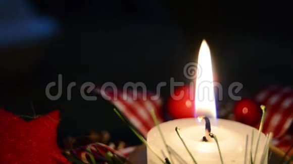 在雪地和木制背景下燃烧蜡烛和圣诞装饰优雅的拍摄与节日的心情视频的预览图