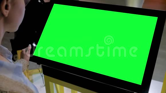 绿色屏幕概念女人看着展览的空白绿色展示亭视频的预览图