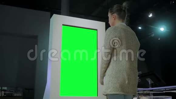 绿色屏幕概念女人看着展览的空白绿色展示亭视频的预览图