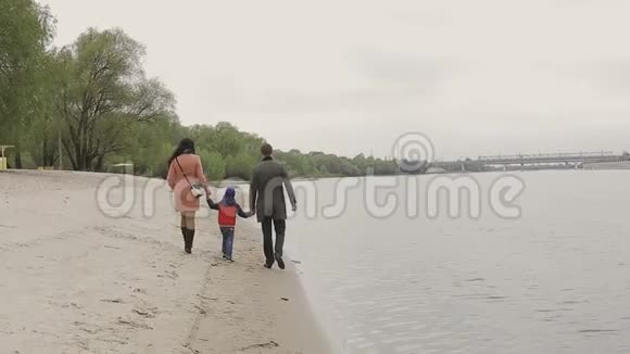 在温暖的天气里家人在河岸散步视频的预览图