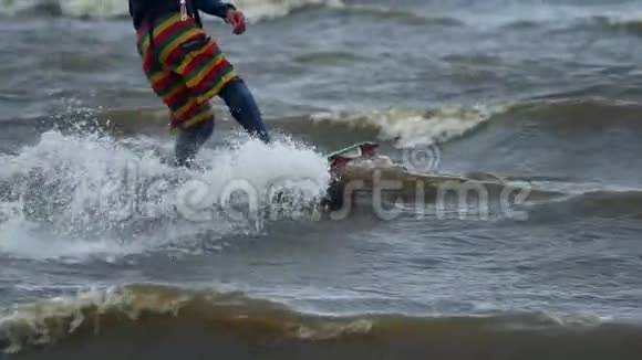 下面的动作一个年轻人在做风筝他在池塘的波浪上漂亮地溜冰强风视频的预览图