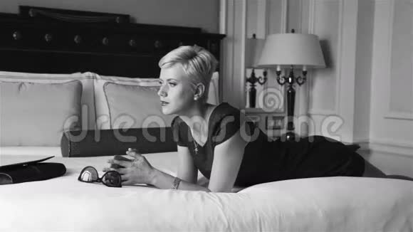美丽的金发商务女性穿着紧身短裙戴着墨镜豪华酒店客房放松休息时尚潮流视频的预览图