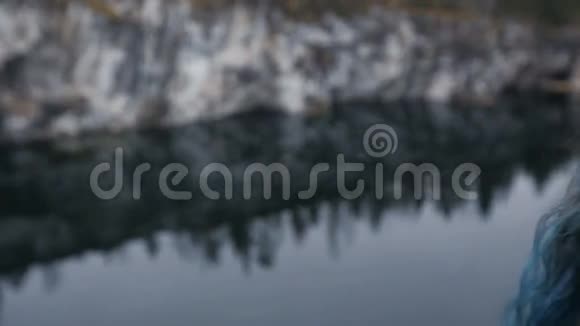 漂亮的女孩喜欢美丽的湖景从山上和良好的天气在卡雷利亚在岩石周围视频的预览图