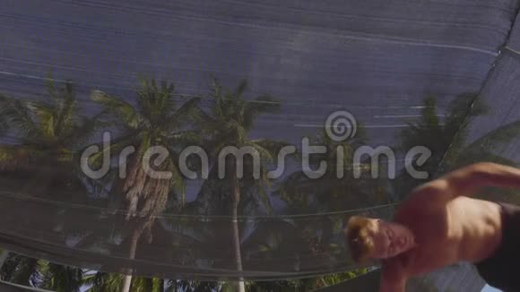 专业体操运动员在蹦床上跳跃慢动作表演视频的预览图