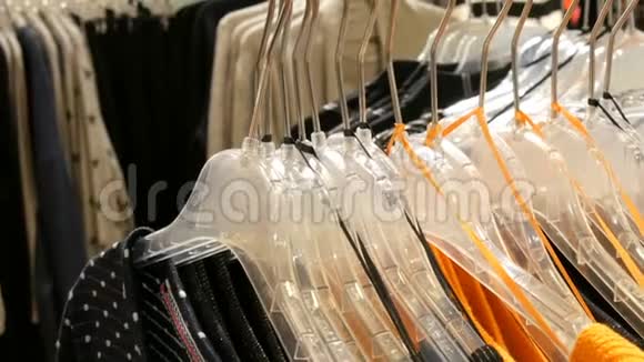 时尚的衣服挂在商场服装店的衣架上视频的预览图