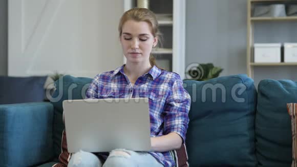 年轻女子在办公室打手提电脑视频的预览图