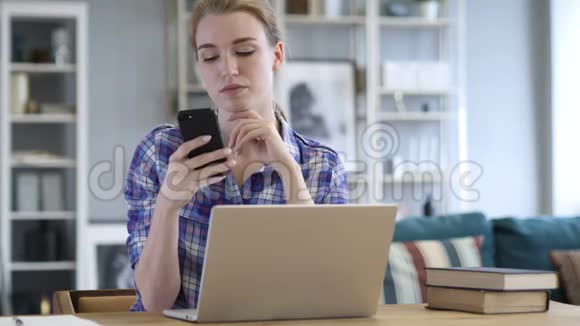女人使用智能手机在工作中上网视频的预览图