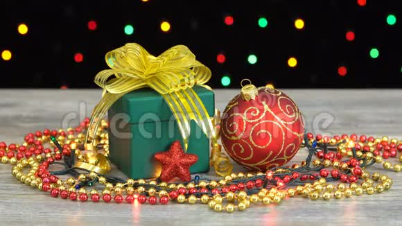 美丽的圣诞礼品盒和装饰在木地板上的彩色闪光花环在黑色视频的预览图