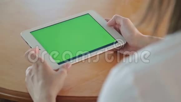 在咖啡馆里看着绿屏平板电脑的女人视频的预览图