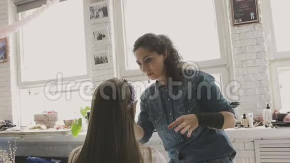 化妆师在照相馆为一个非常漂亮的女孩做专业的化妆视频的预览图