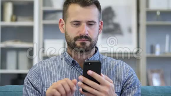 成年男子忙于使用智能手机的肖像视频的预览图