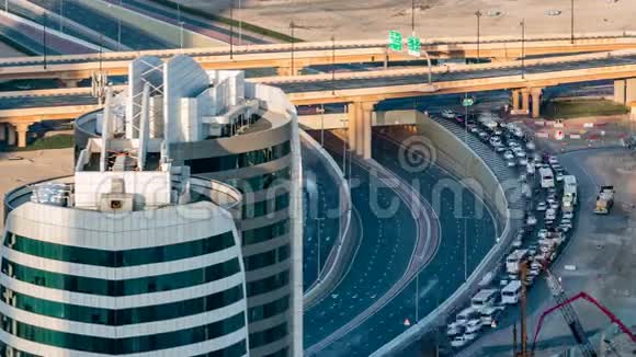 在日落时随着交通时间的推移在阿联酋迪拜的一个高速公路交叉口的鸟瞰图视频的预览图