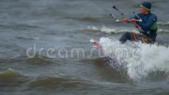 慢动作年轻人从事kiting他在池塘的波浪上漂亮地溜冰强风视频的预览图