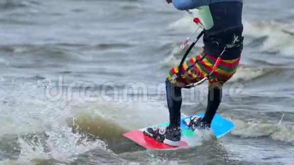 下面的动作一个年轻人在做风筝他在池塘的波浪上漂亮地溜冰强风视频的预览图