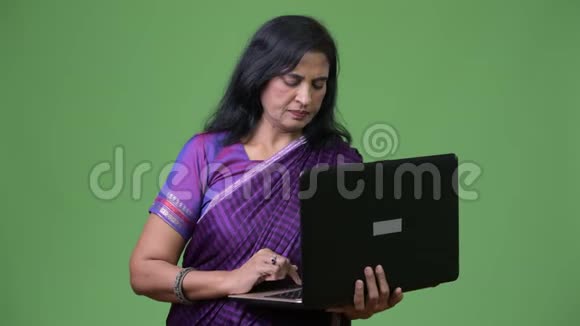 成熟漂亮的印度女人用笔记本电脑视频的预览图