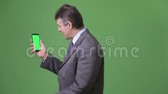 成熟英俊的商人在绿色背景下视频的预览图