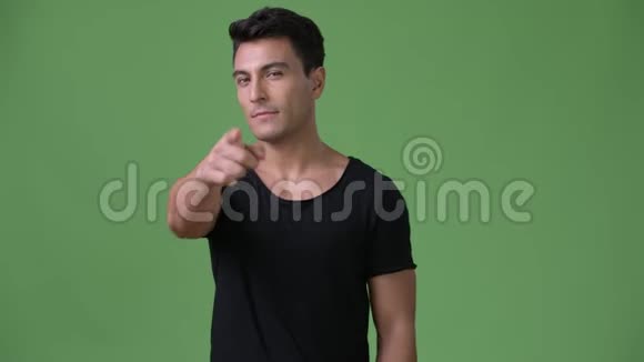 年轻英俊的西班牙男子绿色背景视频的预览图
