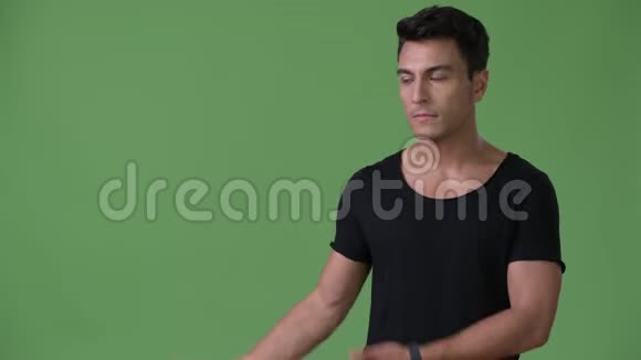 年轻英俊的西班牙男子绿色背景视频的预览图
