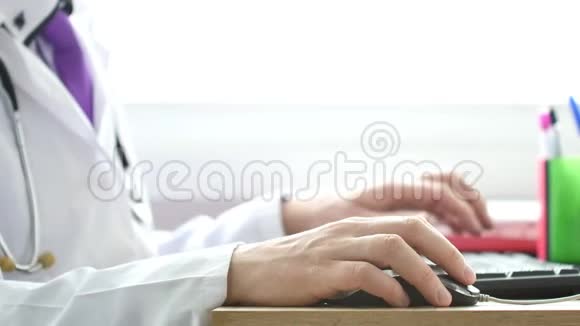 一位医生在他的柜子里用笔记本电脑工作然后点击电脑鼠标视频的预览图
